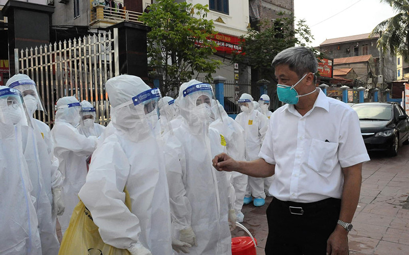 Thứ trưởng Nguyễn Trường Sơn trao đổi, động viên cán bộ y tế thực hiện lấy mẫu ngoài cộng đồng. 