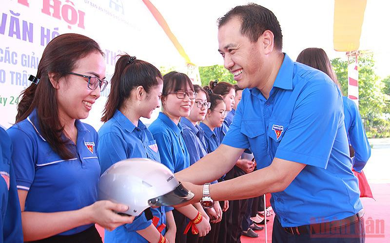 Phó Chủ tịch Thường trực Hội Liên hiệp Thanh niên Việt Nam Nguyễn Hải Minh (bên phải) trao mũ bảo hiểm tặng đoàn viên, thanh niên tham gia Ngày hội “Thanh niên với văn hóa giao thông”.