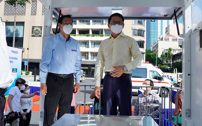 Ông Trần Bá Dương (bên phải) giới thiệu về cơ chế vận hành của xe tiêm chủng cơ động.