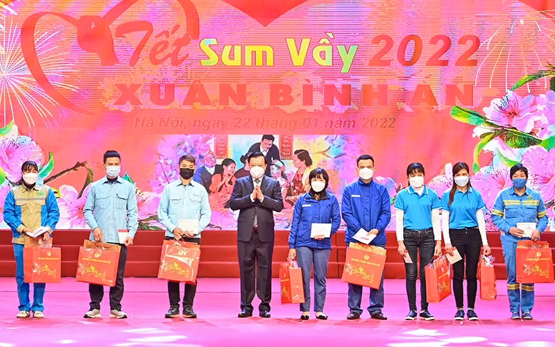 Bí thư Thành ủy Đinh Tiến Dũng tặng quà cho công nhân lao động. (Ảnh: Duy Linh)