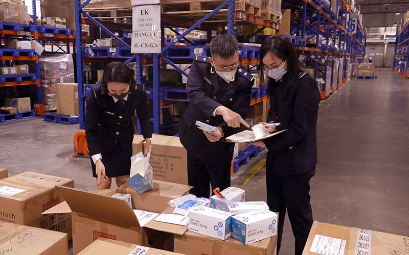 Lực lượng hải quan kiểm tra lô hàng bộ xét nghiệm nhanh Covid-19 vận chuyển từ Hàn Quốc về Việt Nam qua sân bay quốc tế Nội Bài. (Ảnh MINH CHIẾN)