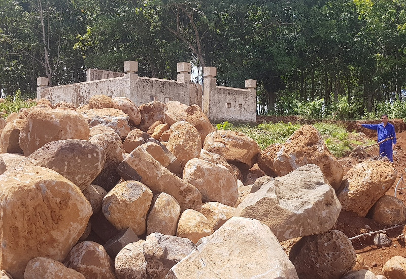 Đá bị múc lên ngổn ngang trước mặt tiền của di tích. 