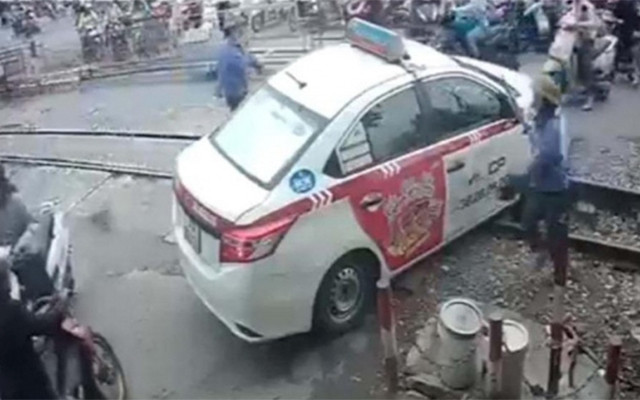 Xe taxi do tài xế Ngô T. L điều khiển vượt rào chắn đường ngang khi chắn đang dịch chuyển. (Ảnh: CAND)