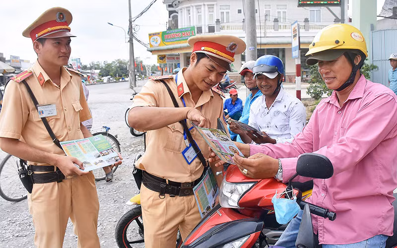 Lực lượng chức năng TP Cần Thơ phát tờ rơi tuyên truyền cho người dân về Nghị định 100/2019/NÐ-CP.