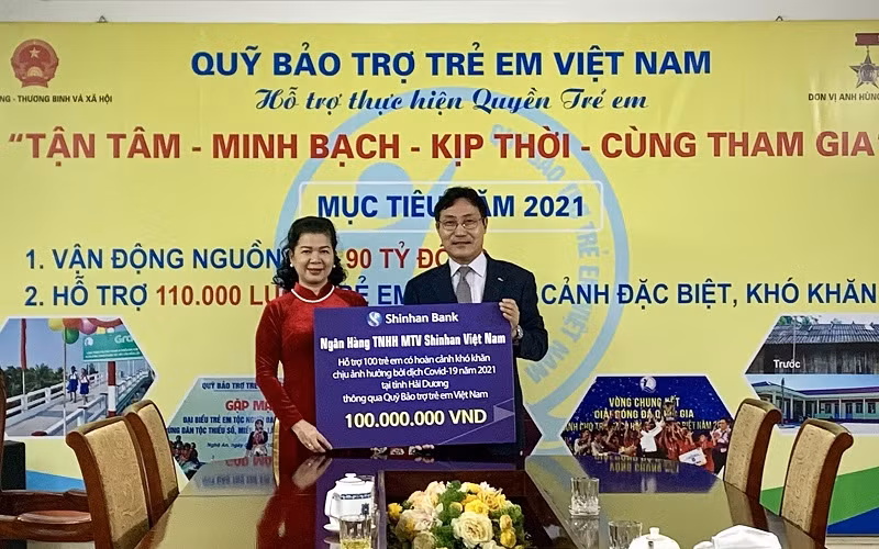 Bà Lê Tuyết Mai, Phó Giám đốc Quỹ Bảo trợ Trẻ em Việt Nam nhận tượng trưng số tiền hỗ trợ cho trẻ em Hải Dương từ ông Cho Mun Sung, Phó Tổng Giám đốc Shinhan Việt Nam.