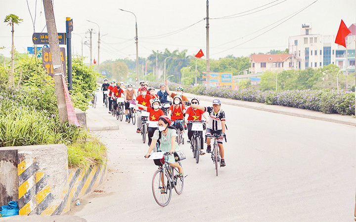 Khách du lịch trải nghiệm tua khám phá làng cổ Bát Tràng bằng xe đạp.