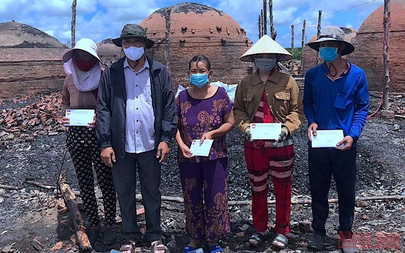 Đại diện Mặt trận Tổ quốc huyện Năm Căn trao hỗ trợ các hộ dân bị ảnh hưởng bởi vụ cháy.