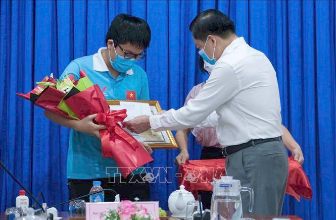 Phó Chủ tịch UBND TP Cần Thơ, Giám đốc Sở Giáo dục và Đào tạo Cần Thơ Dương Tấn Hiển chúc mừng và biểu dương học sinh Đặng Lê Minh Khang (Ảnh: TTXVN)