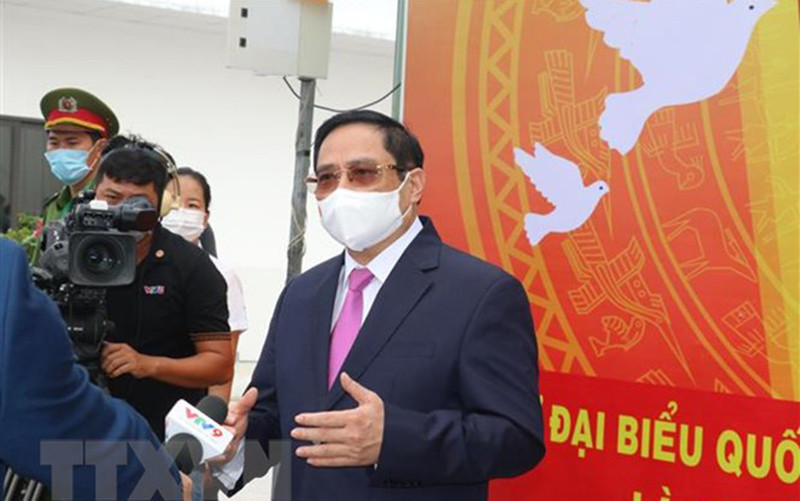 Thủ tướng Phạm Minh Chính gặp gỡ, tiếp xúc báo chí ngay sau khi tham gia bỏ phiếu bầu cử. (Ảnh: Ngọc Thiện/TTXVN).