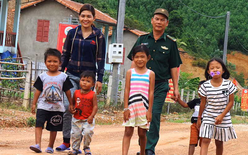 Bí thư Chi bộ kiêm Trưởng bản Hồ Thị Kiên cùng chiến sĩ Đồn Biên phòng Bản Giàng tích cực vận động bà con dân tộc Chứt cho con em mình đến trường.