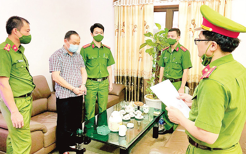 Cơ quan Cảnh sát điều tra Công an tỉnh Tuyên Quang đọc quyết định khởi tố bị can trong vụ án lợi dụng chức vụ, quyền hạn trong khi thi hành công vụ xảy ra tại Công ty Cổ phần Dịch vụ Môi trường và Quản lý đô thị Tuyên Quang, tháng 10/2021. (Ảnh BỘ CÔNG AN) 