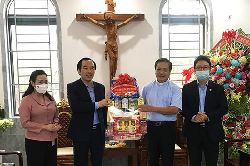 Đồng chí Ngô Sách Thực (thứ 2 từ trái qua) tặng quà, chúc mừng Giáng sinh tại Giáo xứ Tam Tòa.