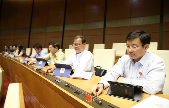 Đại biểu Quốc hội biểu quyết Luật Doanh nghiệp (sửa đổi) sáng 17-6. (Ảnh: DƯƠNG GIANG - TTXVN).