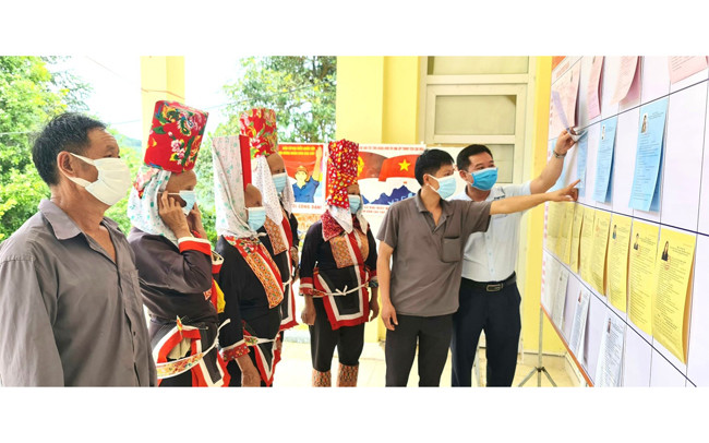 Người dân thôn Ngàn Vàng trên, xã Đồng Tâm, huyện Bình Liêu nghiên cứu tiểu sử các đại biểu được niêm yết tại khu vực bỏ phiếu