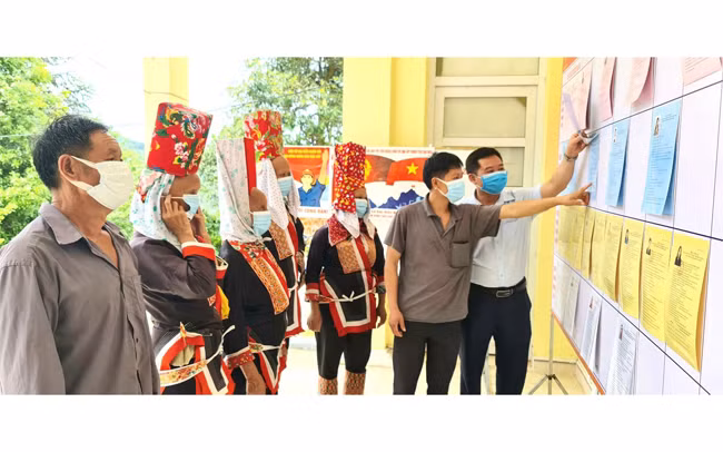 Người dân thôn Ngàn Vàng trên, xã Đồng Tâm, huyện Bình Liêu nghiên cứu tiểu sử các đại biểu được niêm yết tại khu vực bỏ phiếu