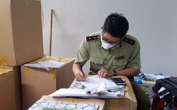 Đội Quản lý thị trường số 7 lập biên bản lô hàng khẩu trang y tế không rõ nguồn gốc.