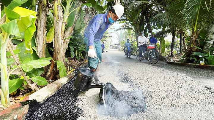 Minh Trung rưới nhựa vá đường.