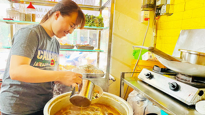 Chị Vương Kim Long đang múc nước lèo vào phần bún bò chay cho khách.