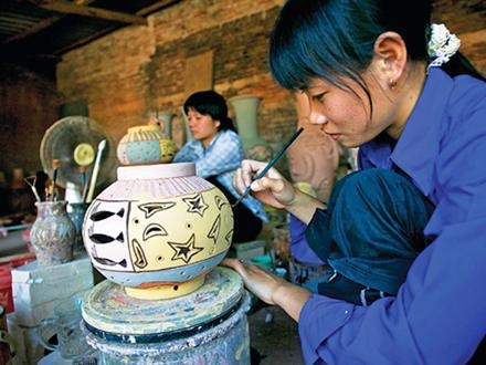 Vẽ hoa văn trang trí lên sản phẩm gốm Thổ Hà.