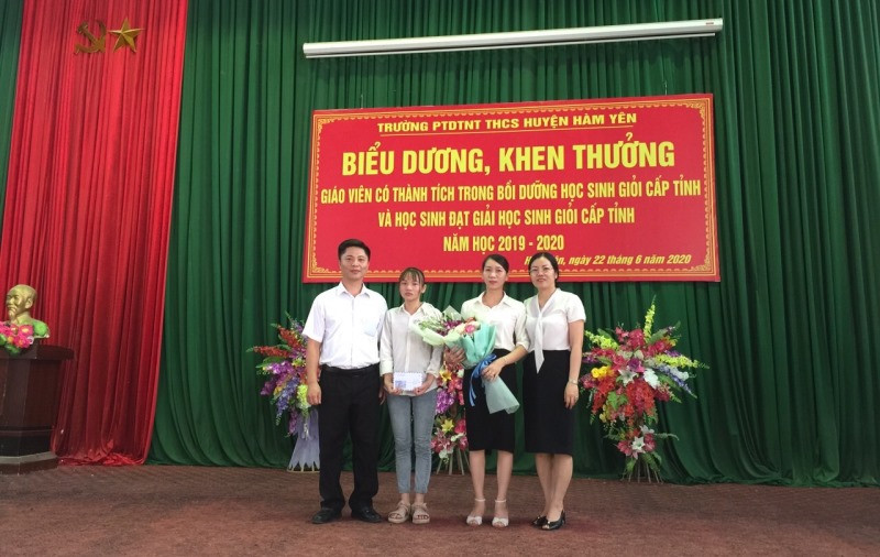 Lê Vân Anh trong vòng tay yêu thương của thầy, cô nhà trường. (Ảnh do BGH Trường THCS nội trú Hàm Yên cung cấp)