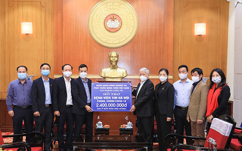 Bí thư Trung ương Đảng, Chủ tịch Ủy ban Trung ương Mặt trận Tổ quốc Việt Nam Đỗ Văn Chiến tiếp nhận ủng hộ từ Ngân hàng Nông nghiệp và Phát triển nông thôn chi nhánh Láng Hạ. (Ảnh: Diệp Vinh)