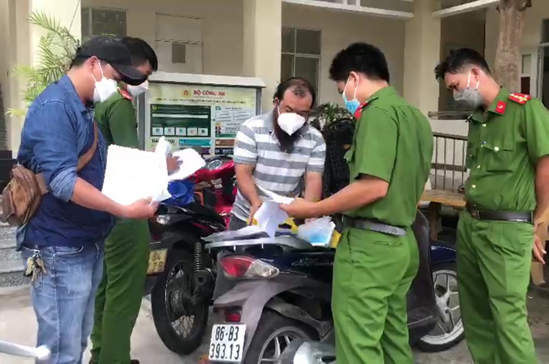 Trần Xuân Đạt (áo sọc ngang), đối tượng chính trong đường dây làm Giấy xét nghiệm Covid-19 giả. 