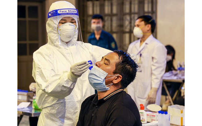 Lực lượng chức năng khẩn trương lấy mẫu xét nghiệm cho các hộ kinh doanh tại chợ Ninh Hiệp.