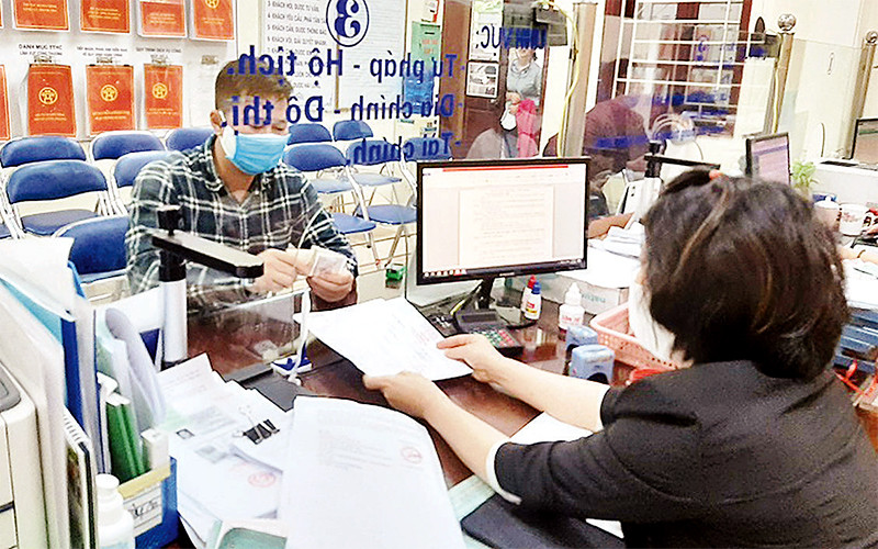 Công chức UBND phường Vĩnh Tuy (quận Hai Bà Trưng) giải quyết hồ sơ hành chính cho công dân. Ảnh: LINH NGUYỄN