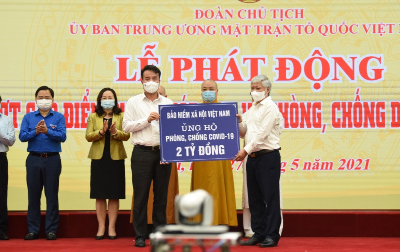 Chủ tịch Ủy ban T.Ư MTTQ Việt Nam Đỗ Văn Chiến tiếp nhận hai tỷ đồng do Tổng Giám đốc BHXH Việt Nam Nguyễn Thế Mạnh - thay mặt toàn thể CCVC ngành BHXH Việt Nam ủng hộ phòng, chống dịch Covid-19. Ảnh: TÂM TRUNG