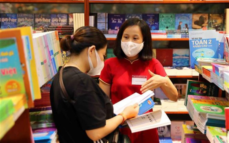 Phụ huynh lựa chọn sách giáo khoa tại hệ thống nhà sách của Nhà xuất bản Giáo dục Việt Nam. (Ảnh: Thành Tùng)