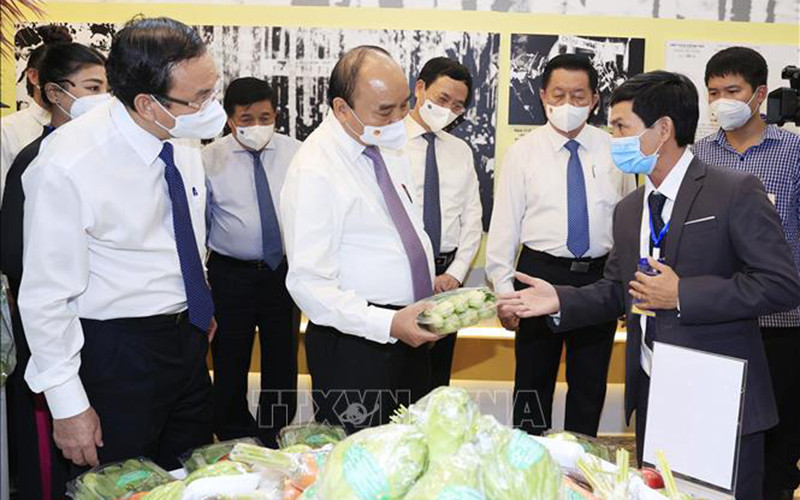 Chủ tịch nước Nguyễn Xuân Phúc thăm khu trưng bày các sản phẩm tiêu biểu của huyện Hóc Môn và Củ Chi. (Ảnh: TTXVN)