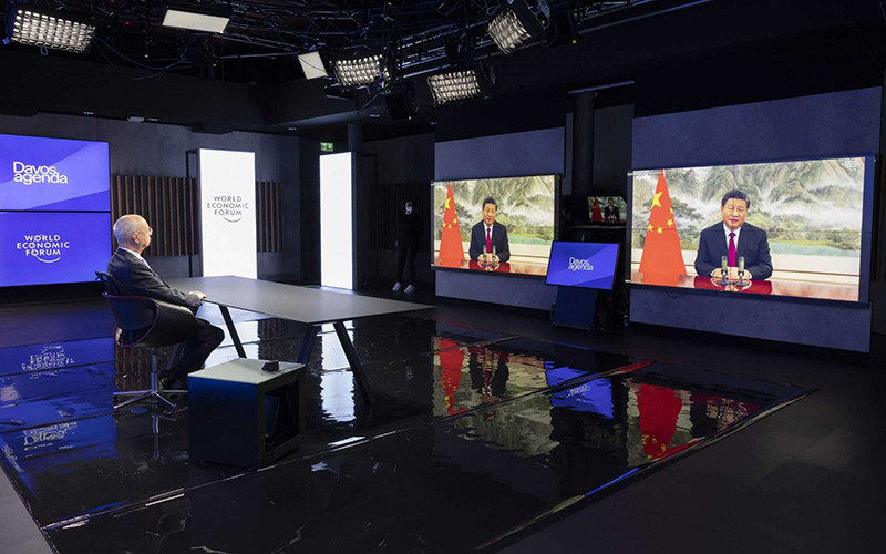 Nhà sáng lập kiêm Chủ tịch Điều hành WEF Klaus Schwab (bên trái) nghe Chủ tịch Trung Quốc Tập Cận Bình (ảnh màn hình) phát biểu tại Hội nghị trực tuyến WEF. (Ảnh: AP)