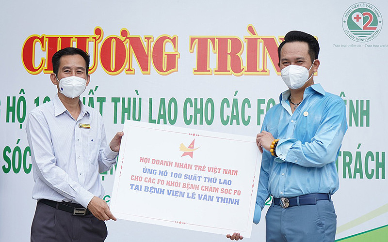 Chủ tịch Hội Doanh nhân trẻ Việt Nam Đặng Hồng Anh (bên phải trong ảnh) trao kinh phí hỗ trợ 100 tình nguyện viên chương trình “ATM F0 chống dịch”.