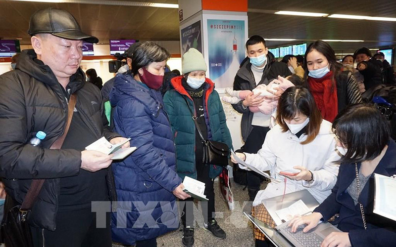 Cán bộ Đại sứ quán Việt Nam tại Ba Lan hỗ trợ thủ tục lên máy bay cho kiều bào sơ tán từ Ukraine. (Ảnh: TTXVN) 
