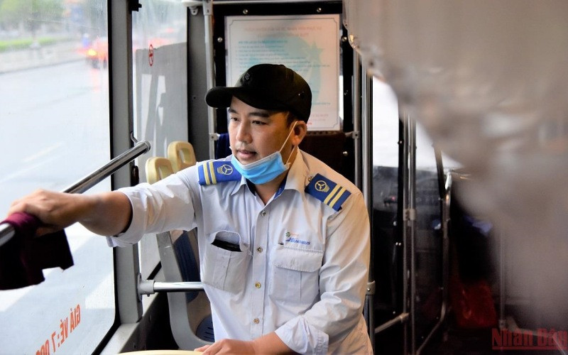 Nhân viên phục vụ trên xe buýt lau rửa nội thất phương tiện từ 4 giờ sáng, trước khi phục vụ người dân. (Ảnh: Minh Duy/NDĐT)