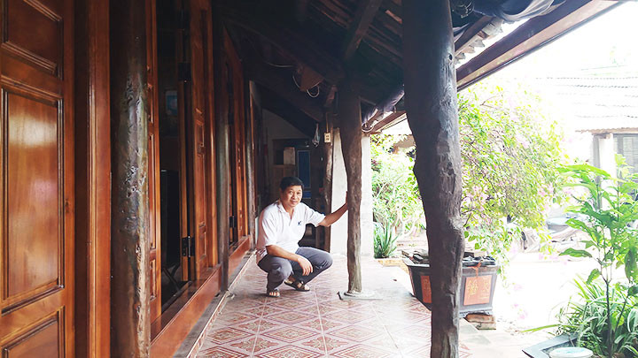 Anh Dương Văn Bình bên những chiếc cột nhà bị đẽo năm xưa.