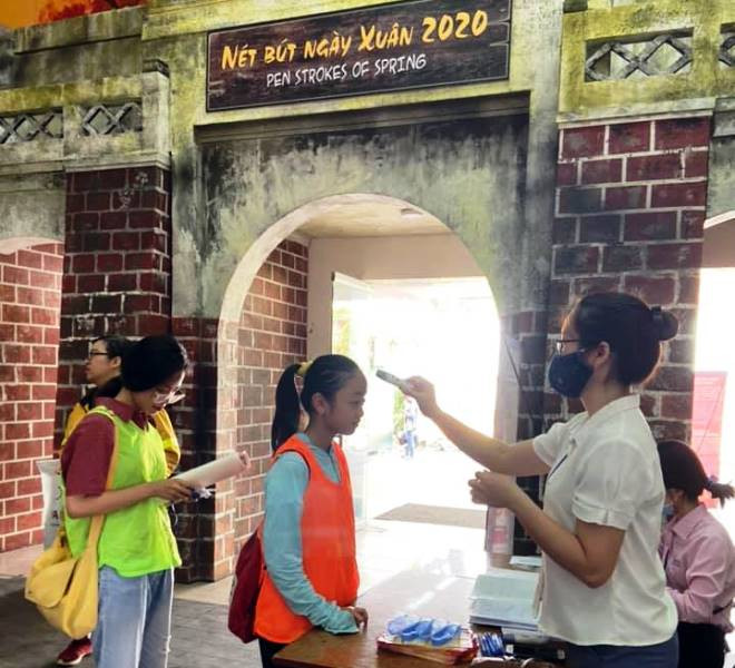 Đo thân nhiệt cho khách tham quan tại di tích Hoàng thành Thăng Long.