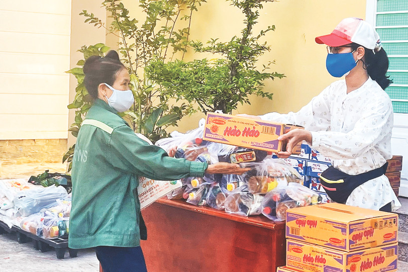 Nhà văn Phương Huyền - Ủy viên BCH Hội NV TPHCM trao quà cho người yếu thế trong mùa dịch.