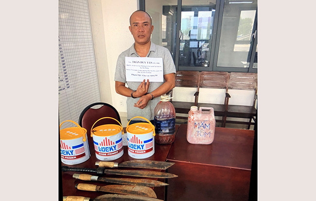 Trần Duy Tân cùng số hung khí và thùng sơn bị thu giữ.