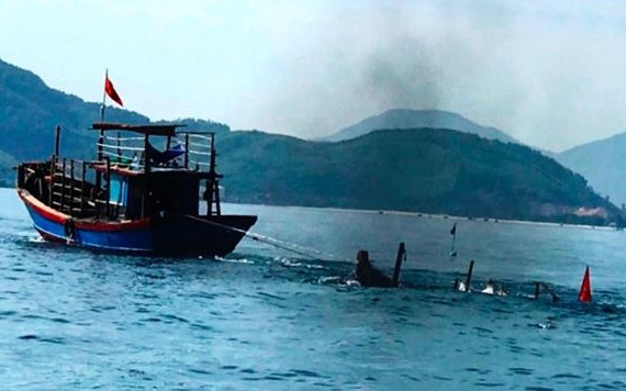 Lực lượng chức năng kéo phương tiện câu mực của ông Thà bị tàu cá đâm chìm trên biển vào bờ.