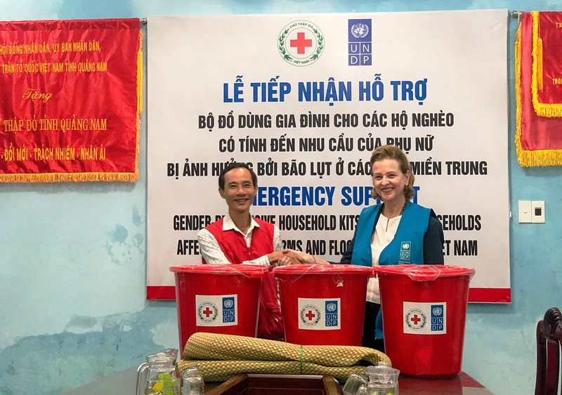 Bà Caitlin Wiesen trao đồ hỗ trợ cho người dân vùng bị ảnh hưởng bão lụt.