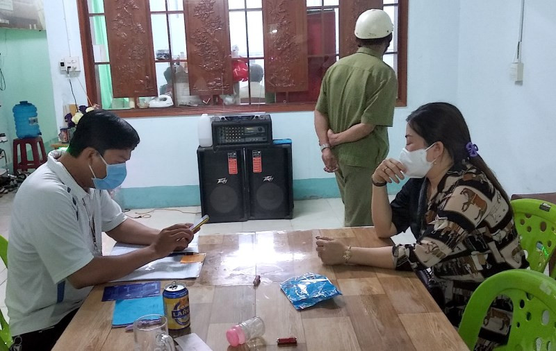 Lực lượng chức năng lập biên bản đối với chủ quán Huyền Cát Tuyền (nữ, bìa phải), tối 2-6.