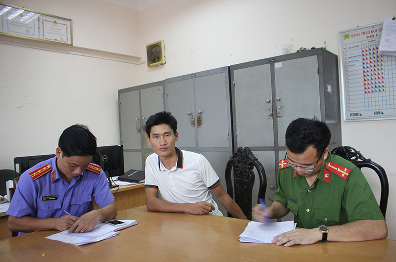 Đối tượng Vàng A Bông (giữa) tại cơ quan công an.