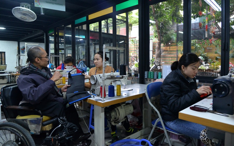 Anh Pham Việt Hoài trao đổi với nhân viên xưởng may về sản phẩm đang hoàn thiện.