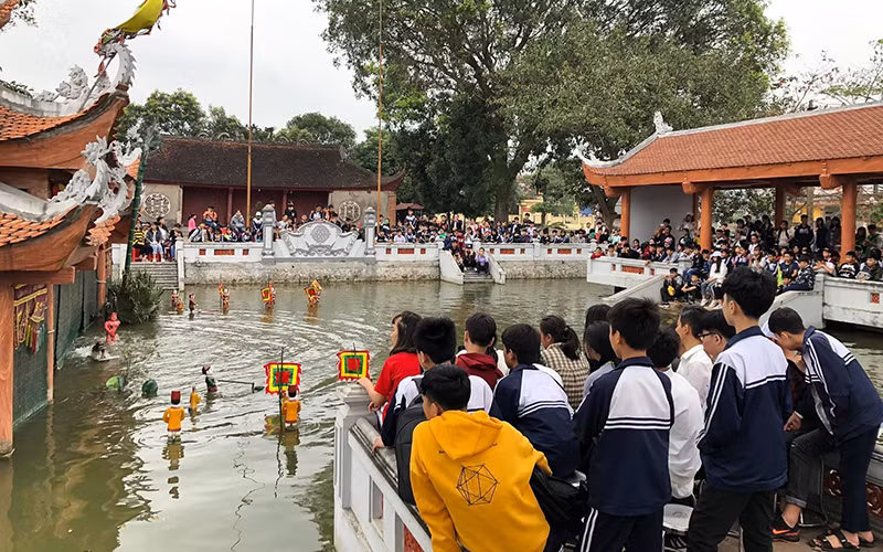 Phường rối nước Ðào Thục biểu diễn phục vụ các em nhỏ (ảnh chụp trước dịch Covid-19).