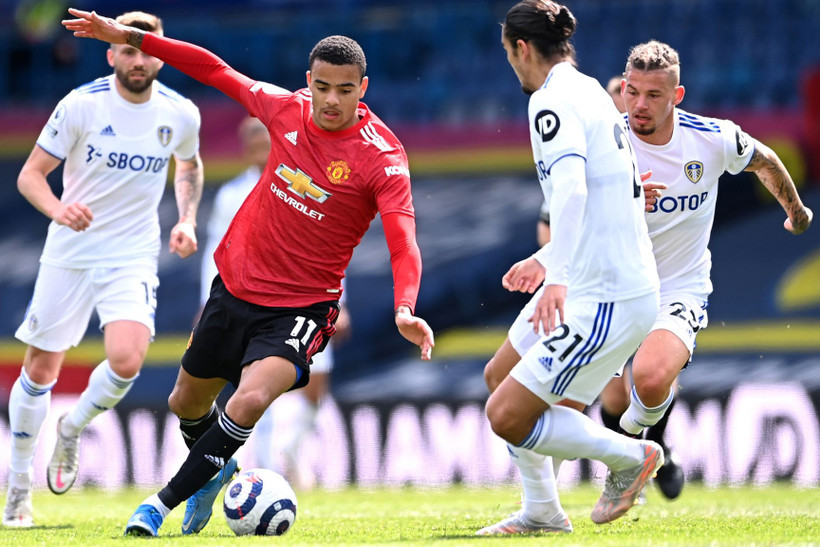 M. Greenwood đi bóng trước sự truy cản của các cầu thủ Leeds.
