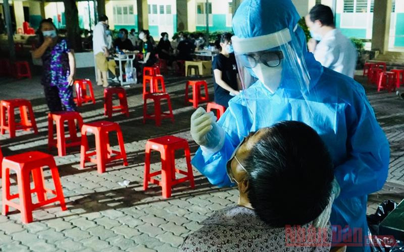 Sinh viên tình nguyện Trường đại học kỹ thuật y tế Hải Dương lấy mẫu xét nghiệm tại Trường THCS Bình Lợi Trung, quận Bình Thạnh, TP Hồ Chí Minh. (Ảnh: VÕ MẠNH HẢO)