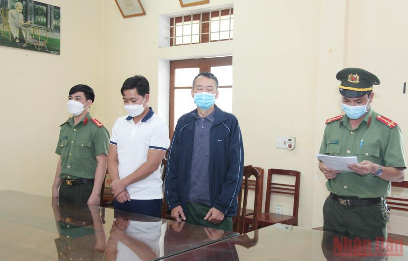 Cơ quan An ninh điều tra đọc lệnh bắt tạm giam đối tượng Khánh và An. (Ảnh: TTXVN)