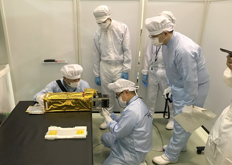 Các chuyên gia Nhật Bản lắp đặt vệ tinh NanoDragon của Việt Nam vào ống phóng của tên lửa.
