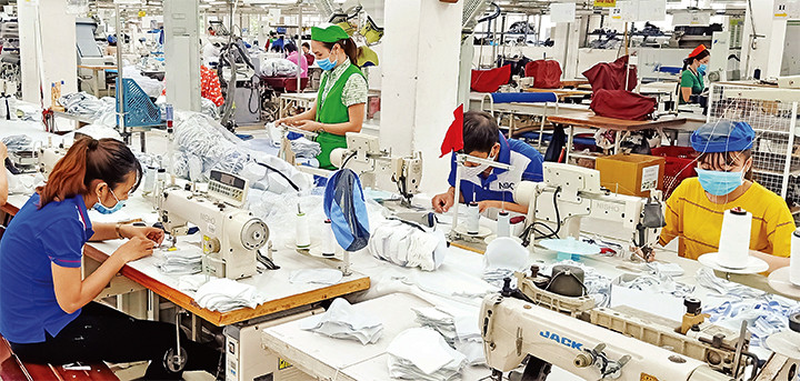 Công nhân làm việc tại dây chuyền may của Công ty May Nhà Bè (quận 4). Ảnh: QUANG QUÝ